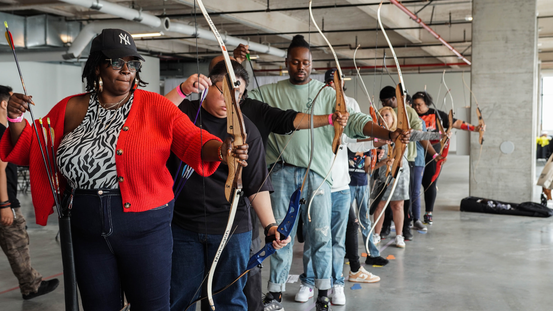 A line of archers at the shooting line, each focused on their own target